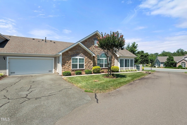 336 Faith Dr, Gibsonville, NC 27249 - ranch-style home featuring stone siding, asphalt driveway, a front lawn, a garage, and a shingled roof