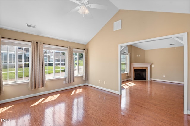 336 Faith Dr, Gibsonville, NC 27249 - unfurnished living room with plenty of natural light, wood finished floors, high vaulted ceiling, a tile fireplace, and ceiling fan