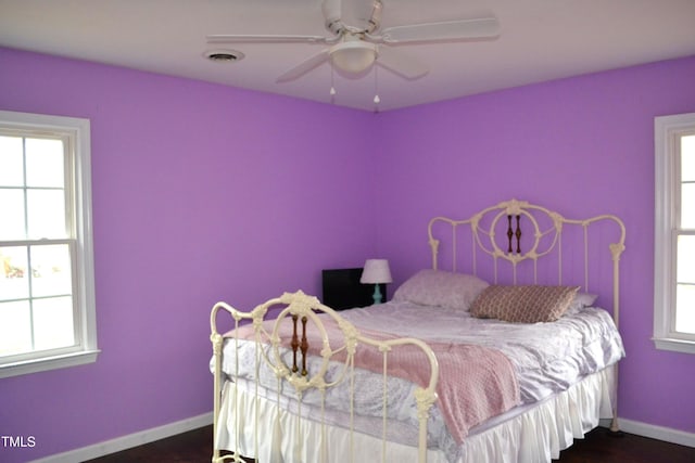 138 Dorsey Pl, Henderson, NC 27536 - bedroom featuring multiple windows, dark wood-style flooring, and a ceiling fan