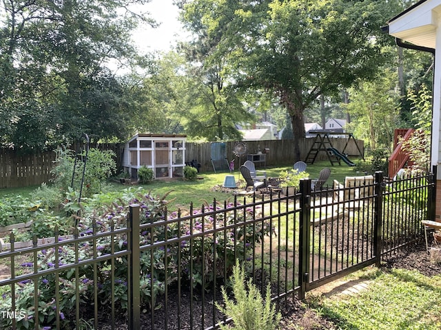 138 Dorsey Pl, Henderson, NC 27536 - fenced backyard featuring a playground and an outbuilding