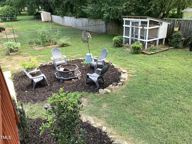138 Dorsey Pl, Henderson, NC 27536 - fenced backyard with a fire pit, an outdoor structure, a garden, and exterior structure