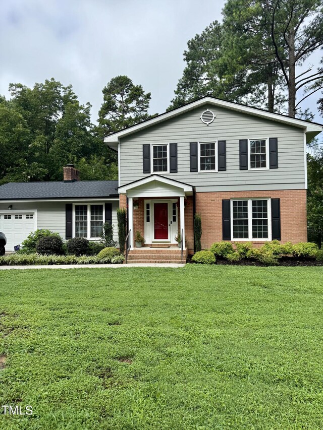 138 Dorsey Pl, Henderson, NC 27536 - view of front of property with a garage, a front lawn, brick siding, and a chimney