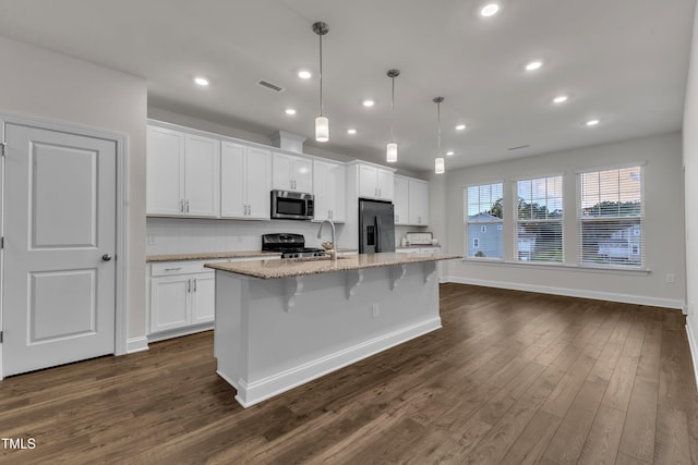2849 Dallas Valley Ln, Apex, NC 27502 - kitchen with stainless steel microwave, black fridge with ice dispenser, a center island with sink, white cabinets, and dark wood-style floors