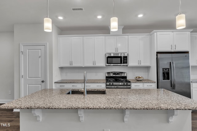 2849 Dallas Valley Ln, Apex, NC 27502 - kitchen with appliances with stainless steel finishes, white cabinets, an island with sink, decorative backsplash, and dark wood-style flooring