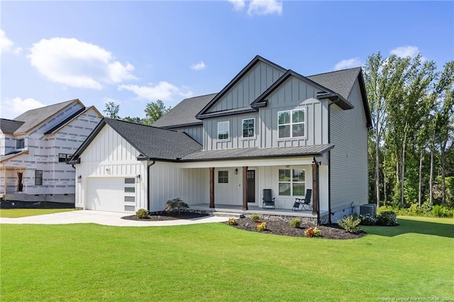 412 Stable Ct, Linden, NC 28356 - modern farmhouse style home with board and batten siding, a porch, a front yard, a garage, and driveway