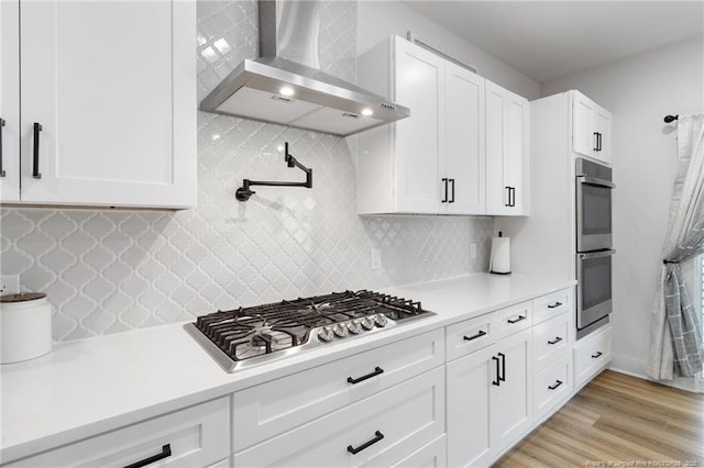 412 Stable Ct, Linden, NC 28356 - kitchen with wall chimney exhaust hood, appliances with stainless steel finishes, light countertops, and white cabinetry