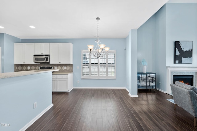 308 Minton Valley Ln, Cary, NC 27519 - kitchen with stainless steel microwave, white cabinets, a chandelier, dark wood-type flooring, and recessed lighting