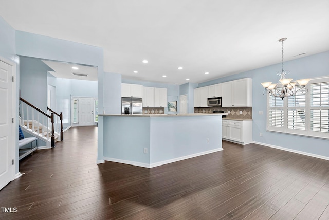 308 Minton Valley Ln, Cary, NC 27519 - kitchen with stainless steel appliances, a chandelier, decorative backsplash, white cabinets, and dark wood-style flooring