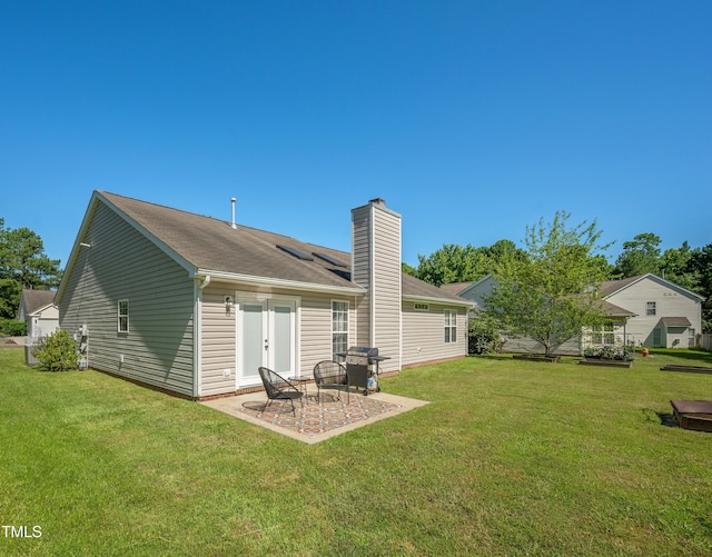 10 N Berrymeadow Ln, Durham, NC 27703 - rear view of house with a chimney, a patio, and a yard