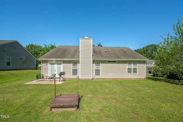 10 N Berrymeadow Ln, Durham, NC 27703 - back of property featuring a yard, an outdoor fire pit, a chimney, and a patio area