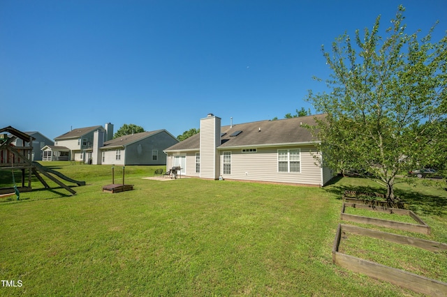 10 N Berrymeadow Ln, Durham, NC 27703 - back of house with a vegetable garden, a yard, a playground, and a chimney