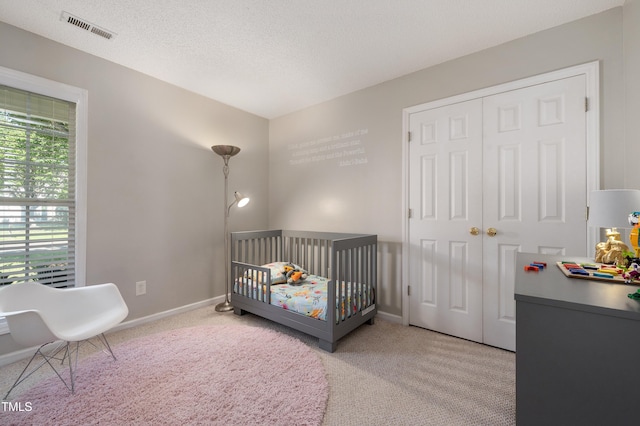 10 N Berrymeadow Ln, Durham, NC 27703 - bedroom featuring carpet floors, a closet, a nursery area, and a textured ceiling