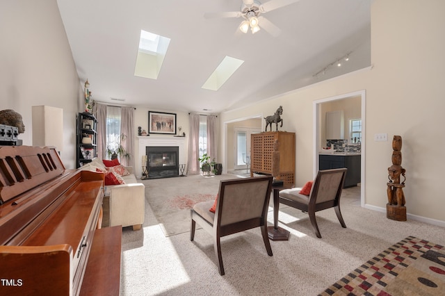 10 N Berrymeadow Ln, Durham, NC 27703 - living room featuring light carpet, a skylight, a fireplace with flush hearth, and a ceiling fan