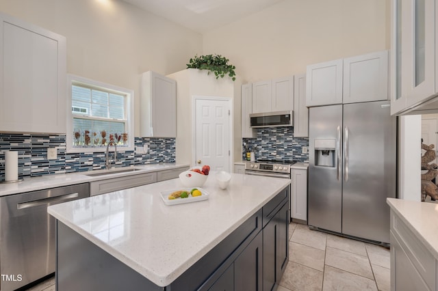 10 N Berrymeadow Ln, Durham, NC 27703 - kitchen with stainless steel appliances, decorative backsplash, a center island, light stone countertops, and light tile patterned floors