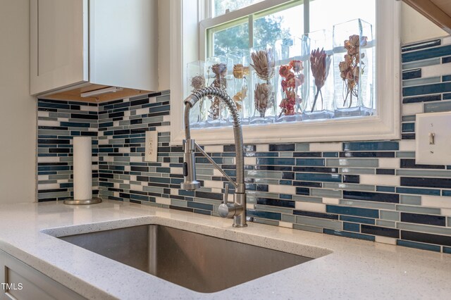 10 N Berrymeadow Ln, Durham, NC 27703 - kitchen view of decorative backsplash, light stone counters, and white cabinets