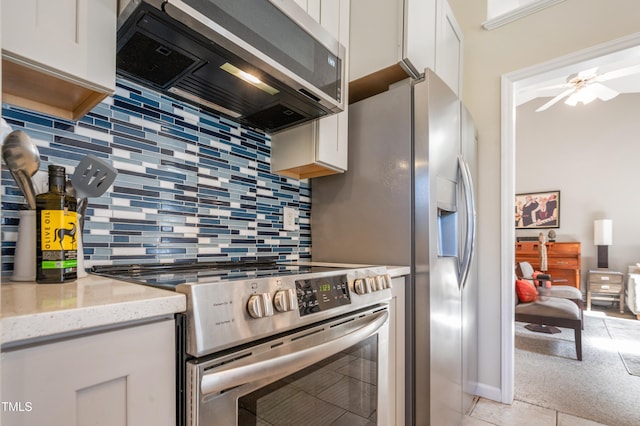 10 N Berrymeadow Ln, Durham, NC 27703 - kitchen with appliances with stainless steel finishes, ventilation hood, white cabinets, decorative backsplash, and light stone counters