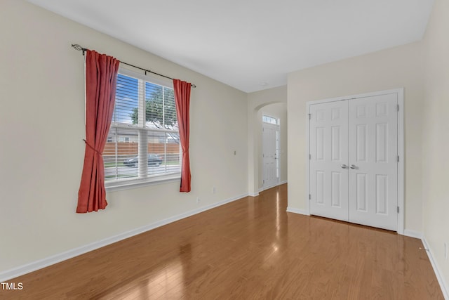 2801 Casona Way, Raleigh, NC 27616 - unfurnished bedroom with wood finished floors, arched walkways, and a closet