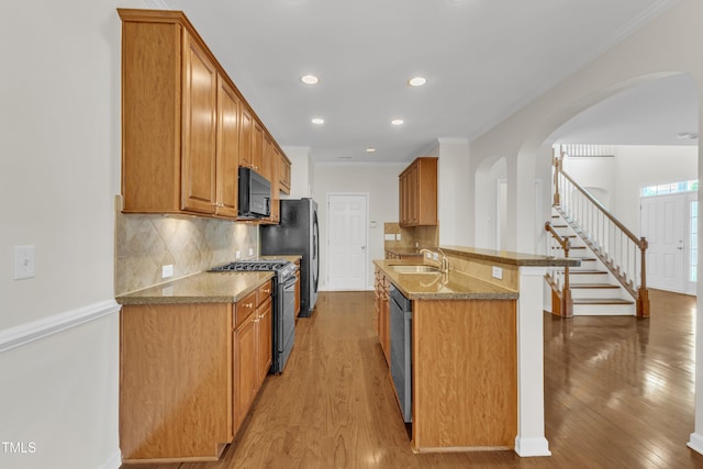 2801 Casona Way, Raleigh, NC 27616 - kitchen featuring appliances with stainless steel finishes, arched walkways, light wood-type flooring, crown molding, and recessed lighting