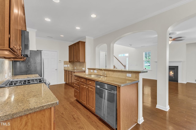 2801 Casona Way, Raleigh, NC 27616 - kitchen with stainless steel appliances, brown cabinets, backsplash, light wood finished floors, and light stone counters