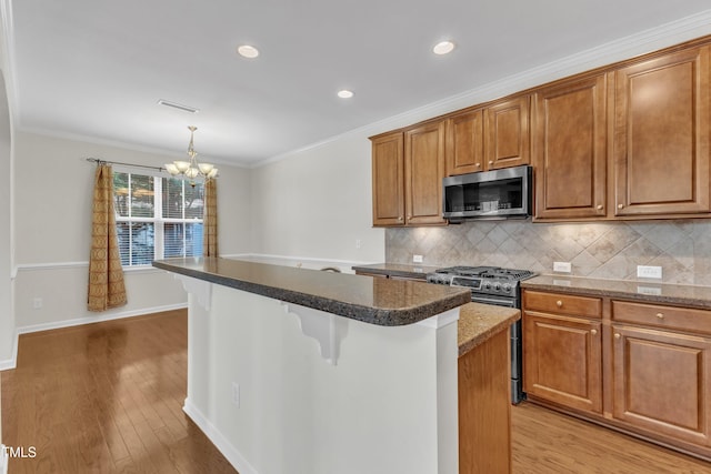2801 Casona Way, Raleigh, NC 27616 - kitchen with stainless steel appliances, a chandelier, decorative backsplash, a center island, and a breakfast bar