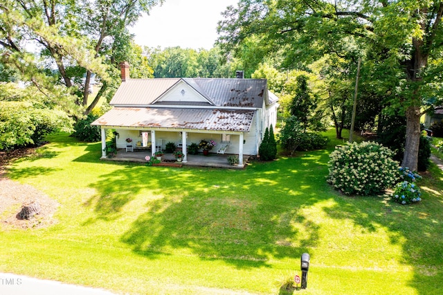 7167 Adolph Rd, Bailey, NC 27807 - rear view of house featuring a porch, a lawn, a chimney, and view of wooded area