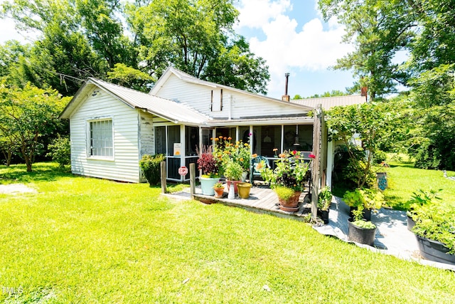 7167 Adolph Rd, Bailey, NC 27807 - back of house featuring a sunroom, a lawn, and a metal roof