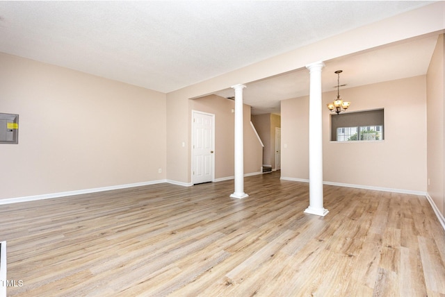 424 Nomar, Raleigh, NC 27610 - unfurnished living room featuring light wood-style flooring, a chandelier, and ornate columns