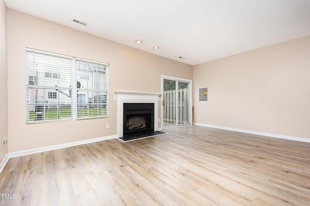 424 Nomar, Raleigh, NC 27610 - unfurnished living room featuring light wood-type flooring, a fireplace, recessed lighting, and electric panel