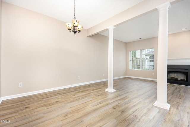 424 Nomar, Raleigh, NC 27610 - unfurnished living room with a fireplace, light wood-style flooring, a chandelier, and decorative columns