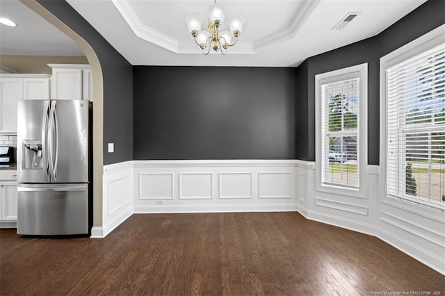 17 Tanawha Ct, Spring Lake, NC 28390 - unfurnished dining area featuring arched walkways, dark wood finished floors, a wainscoted wall, a chandelier, and a tray ceiling