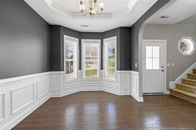 17 Tanawha Ct, Spring Lake, NC 28390 - entryway with a chandelier, dark wood-style floors, arched walkways, wainscoting, and a tray ceiling