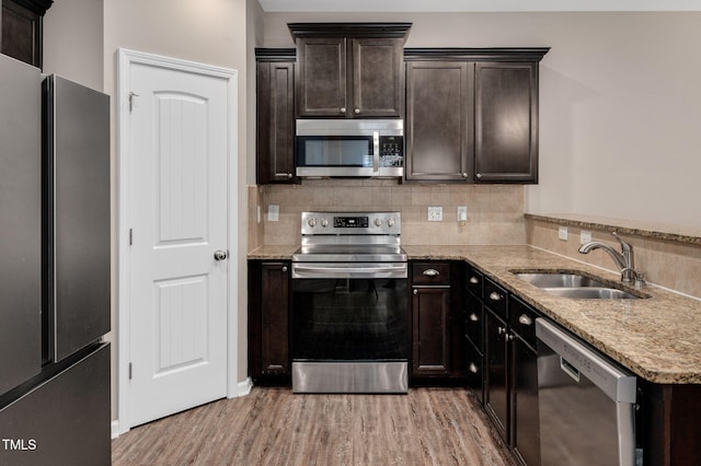 516 Smithridge Way, Fuquay Varina, NC 27526 - kitchen with stainless steel appliances, light wood finished floors, tasteful backsplash, light stone countertops, and dark brown cabinetry