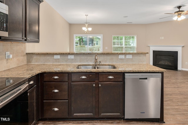 516 Smithridge Way, Fuquay Varina, NC 27526 - kitchen featuring stainless steel appliances, wood finished floors, dark brown cabinetry, a peninsula, and light stone countertops