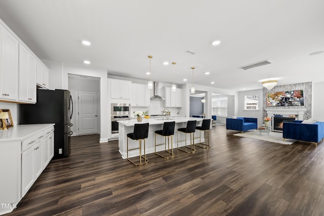 1705 Pointe Xing, Apex, NC 27523 - kitchen with wall chimney range hood, stainless steel appliances, open floor plan, light countertops, and tasteful backsplash