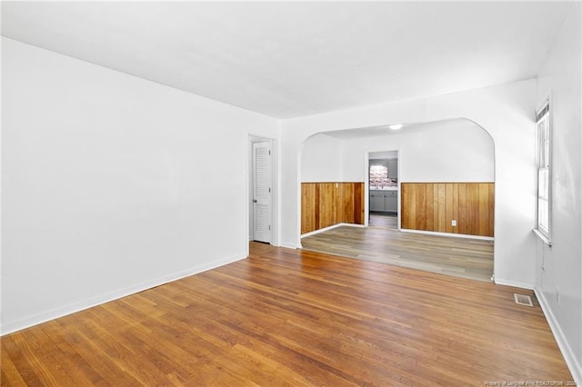 1109 Chesterfield Dr, Fayetteville, NC 28305 - spare room with a wainscoted wall, arched walkways, and wood finished floors