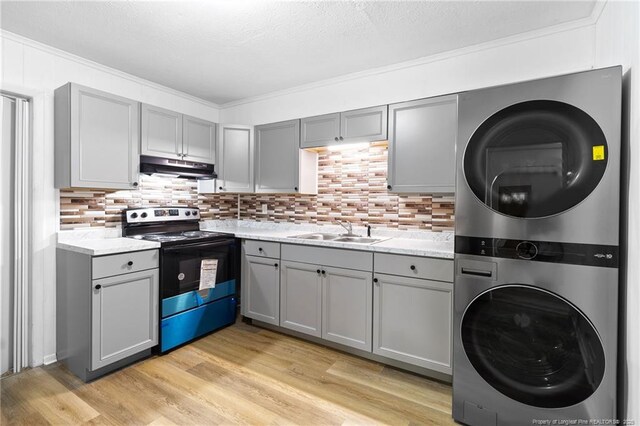1109 Chesterfield Dr, Fayetteville, NC 28305 - kitchen featuring range with electric stovetop, stacked washer and clothes dryer, gray cabinets, under cabinet range hood, and light countertops