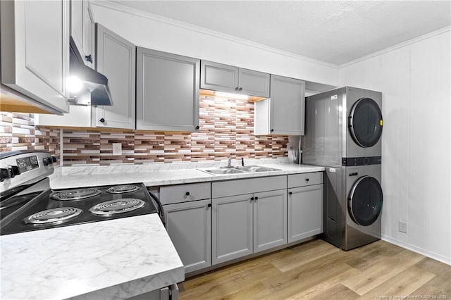 1109 Chesterfield Dr, Fayetteville, NC 28305 - kitchen with stacked washer / drying machine, gray cabinets, stainless steel electric range, under cabinet range hood, and crown molding