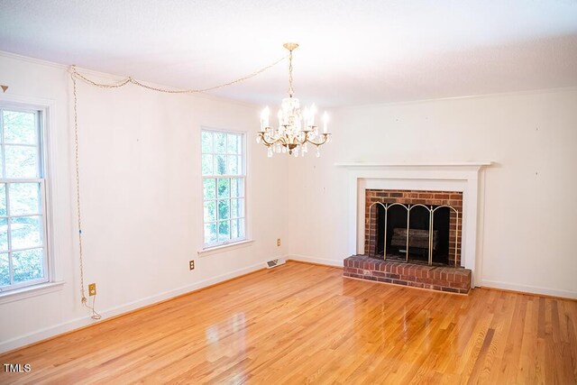 70 Sand Trap Ln, Roxboro, NC 27574 - unfurnished living room with wood finished floors, a chandelier, ornamental molding, and a fireplace