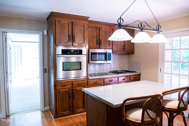 70 Sand Trap Ln, Roxboro, NC 27574 - kitchen featuring stainless steel appliances, light wood finished floors, a kitchen breakfast bar, backsplash, and crown molding