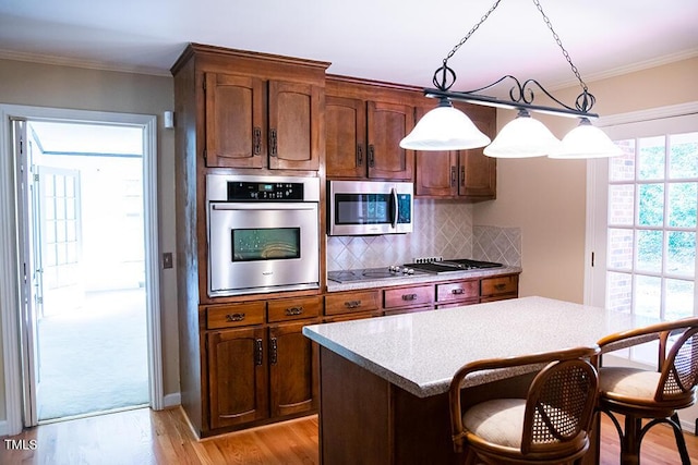 70 Sand Trap Ln, Roxboro, NC 27574 - kitchen with appliances with stainless steel finishes, light wood-style floors, a breakfast bar, ornamental molding, and tasteful backsplash