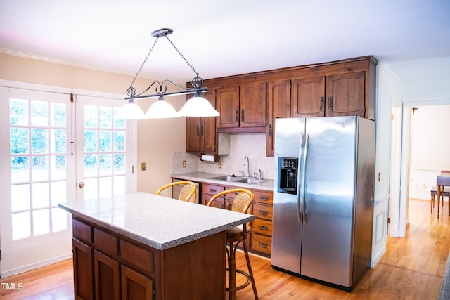 70 Sand Trap Ln, Roxboro, NC 27574 - kitchen featuring stainless steel refrigerator with ice dispenser, a kitchen island, crown molding, backsplash, and light wood-type flooring