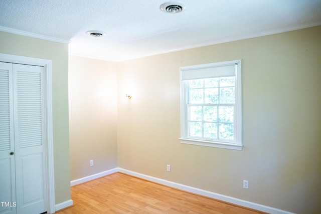 70 Sand Trap Ln, Roxboro, NC 27574 - unfurnished bedroom featuring crown molding, light wood finished floors, a closet, and a textured ceiling