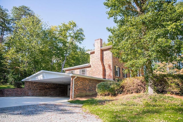70 Sand Trap Ln, Roxboro, NC 27574 - view of property exterior with driveway, brick siding, a chimney, and an attached carport