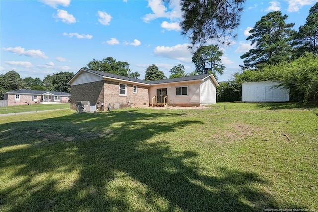 2619 Dumfries Dr, Fayetteville, NC 28306 - back of house with a lawn, brick siding, and a storage unit