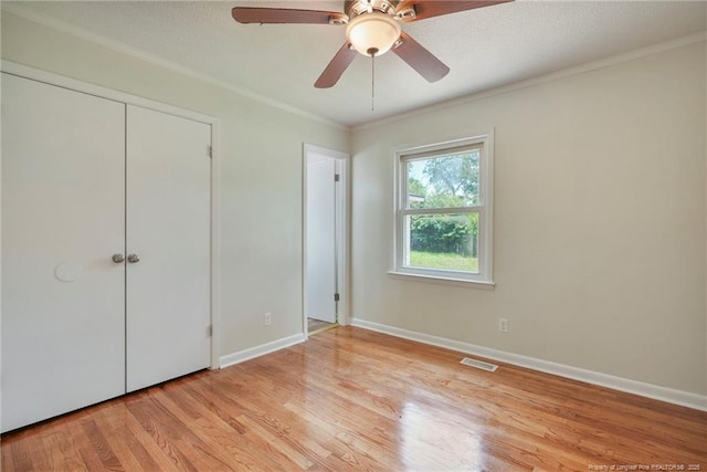 2619 Dumfries Dr, Fayetteville, NC 28306 - unfurnished bedroom featuring crown molding, light wood-style flooring, a ceiling fan, and a closet