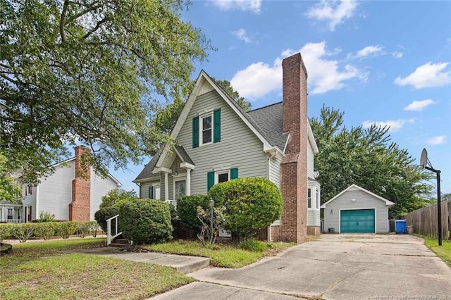 3464 Mcchoen Dr, Fayetteville, NC 28311 - view of front of property featuring an outdoor structure, a garage, a chimney, and driveway