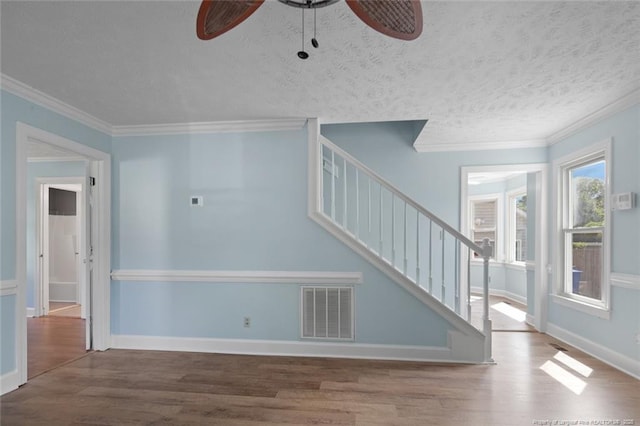 3464 Mcchoen Dr, Fayetteville, NC 28311 - unfurnished living room featuring a ceiling fan, wood finished floors, stairway, ornamental molding, and a textured ceiling