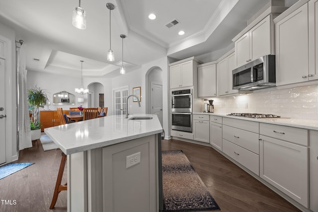 1372 Prevenient Dr, Wake Forest, NC 27587 - kitchen with a raised ceiling, appliances with stainless steel finishes, arched walkways, ornamental molding, and backsplash