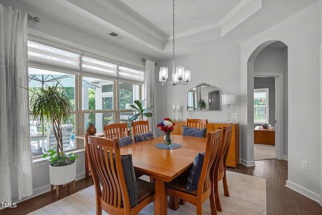 1372 Prevenient Dr, Wake Forest, NC 27587 - dining room featuring a tray ceiling, wood finished floors, ornamental molding, arched walkways, and a chandelier