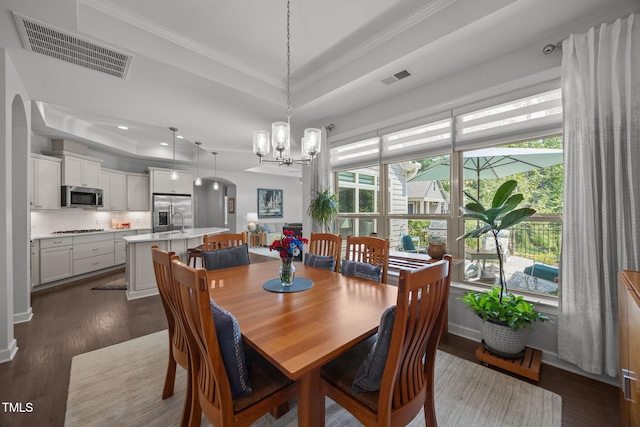 1372 Prevenient Dr, Wake Forest, NC 27587 - dining space with a tray ceiling, a chandelier, dark wood finished floors, crown molding, and arched walkways